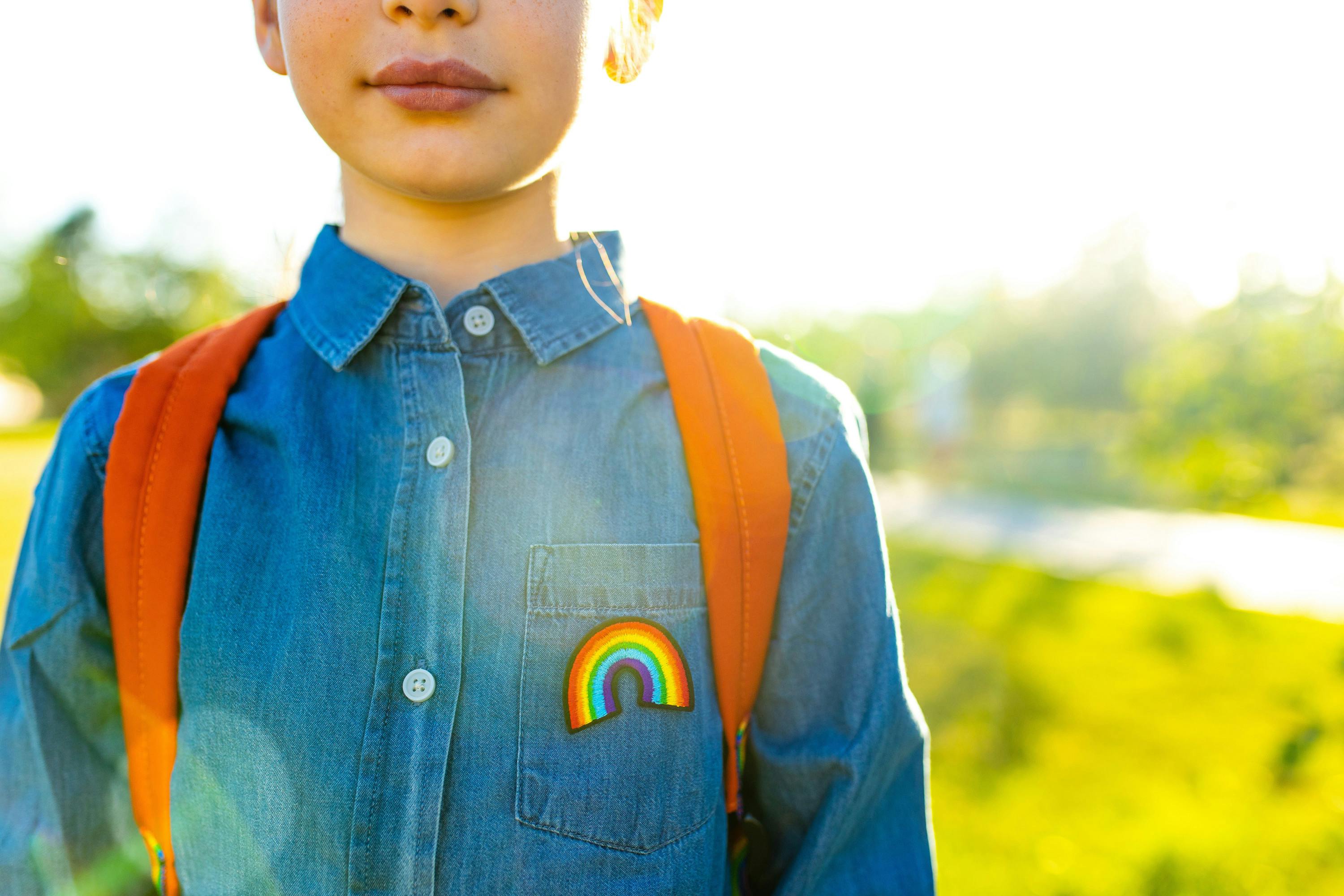 child with rainbow pin