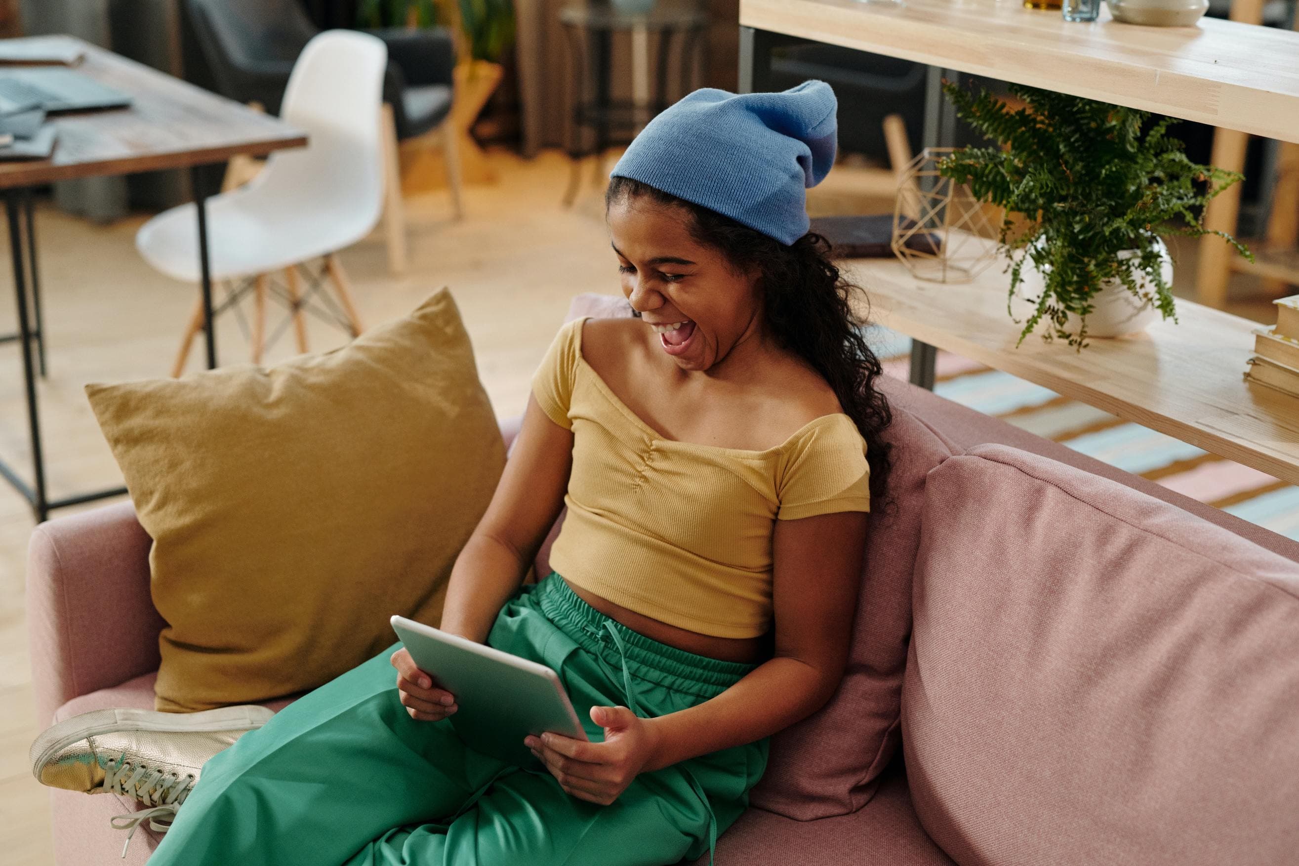 Kid sitting on couch looking at tablet