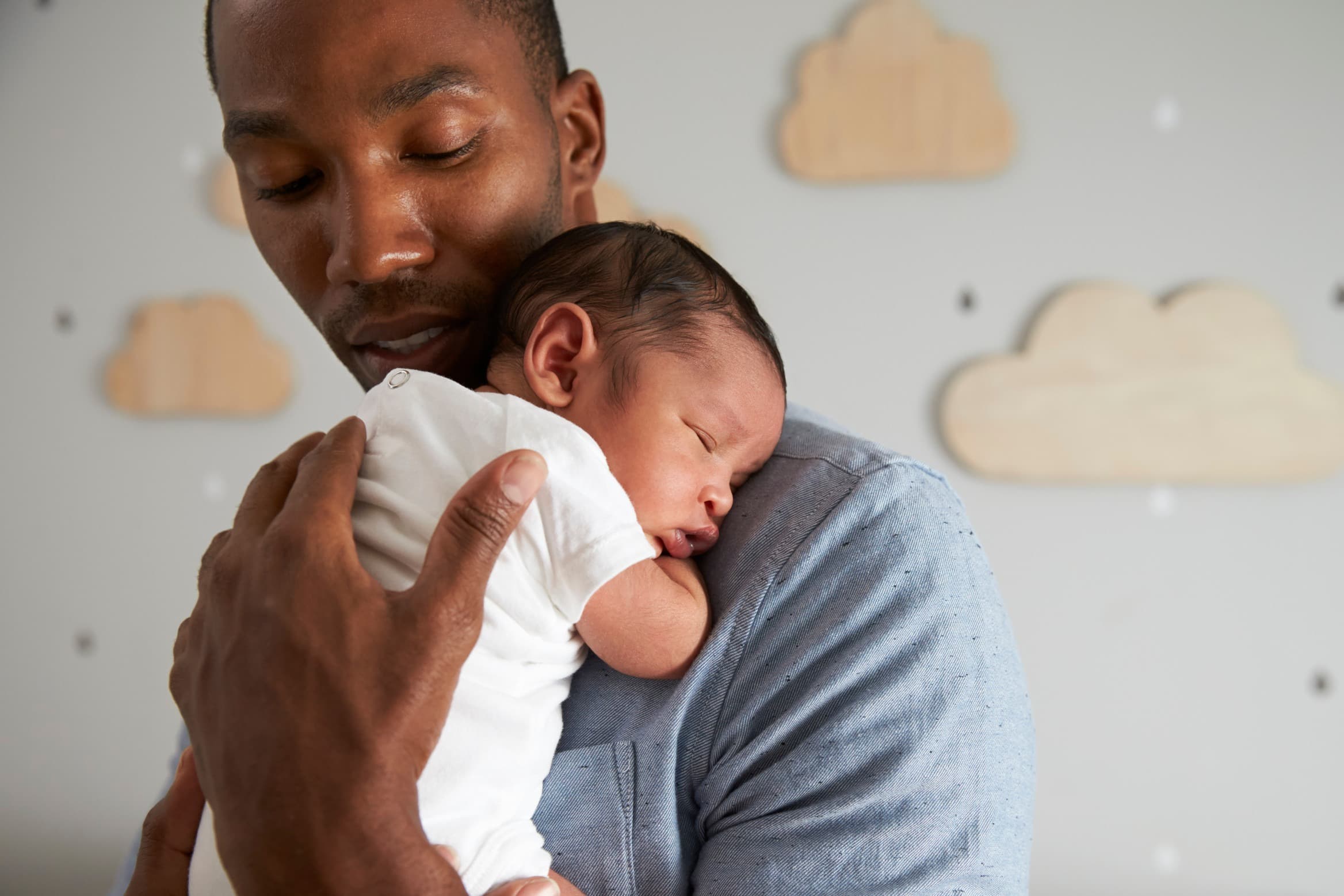 Father holding baby in nursery