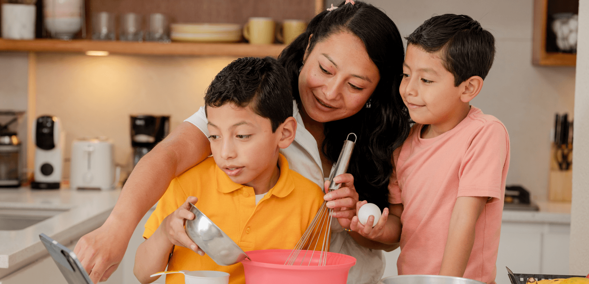 Two young boys cooking in kitchen with mom